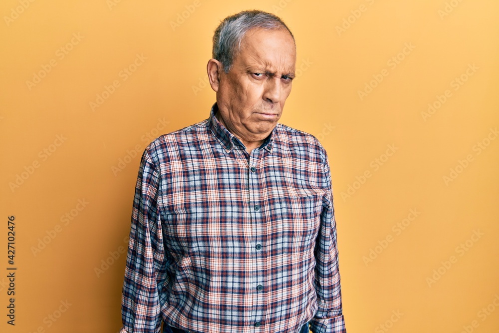Handsome senior man with grey hair wearing casual shirt skeptic and nervous, frowning upset because of problem. negative person. Handsome senior man with grey hair wearing casual shirt skeptic and nervous, frowning upset because of problem. negative person.