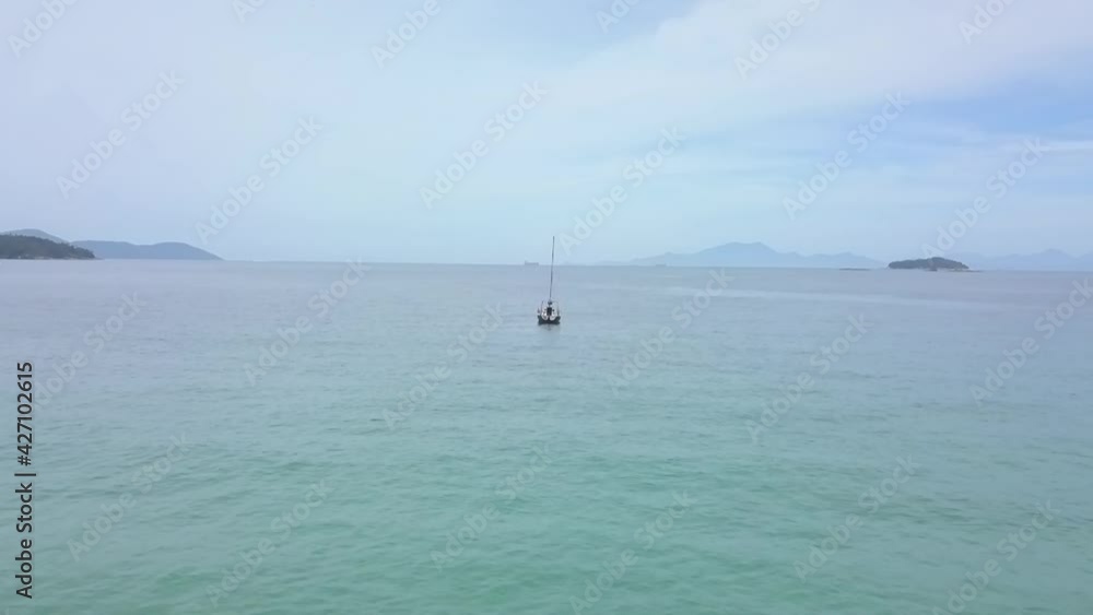 Aerial and slow motion view of a sailboat on a paradisiacal beach in the bay of Angra dos Reis, Rio de Janeiro, Brazil Aerial and slow motion view of a sailboat on a paradisiacal beach in the bay of Angra dos Reis, Rio de Janeiro, Brazil