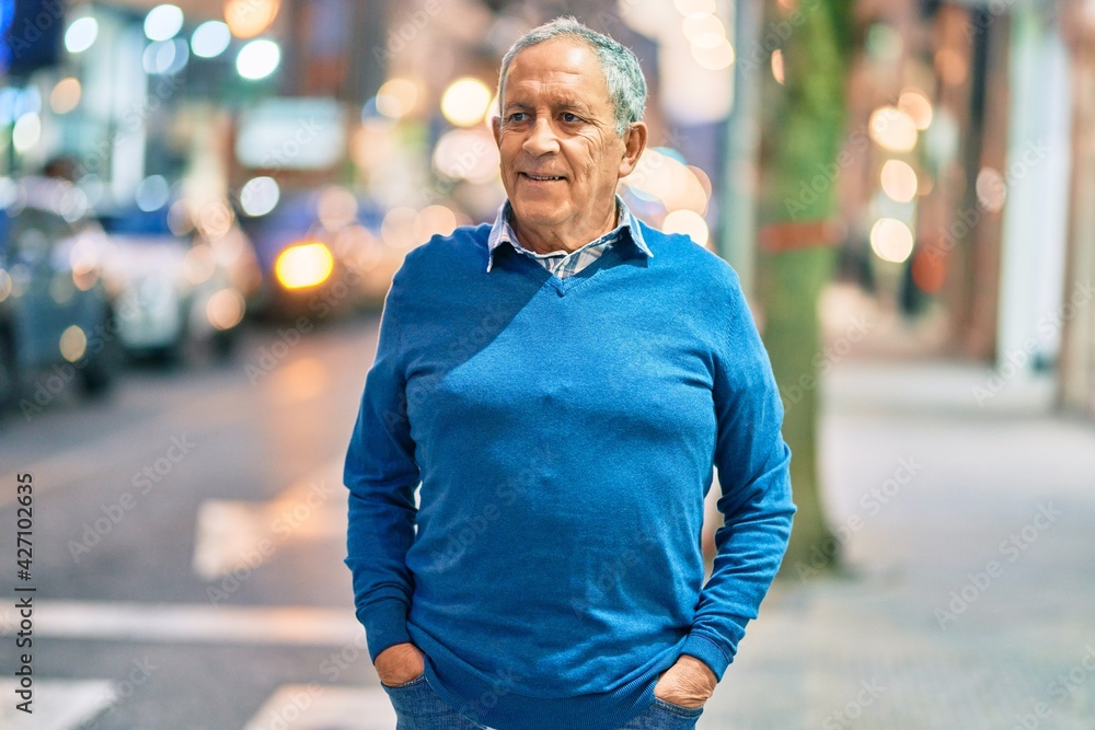 Senior grey-haired man smiling happy standing at the city.