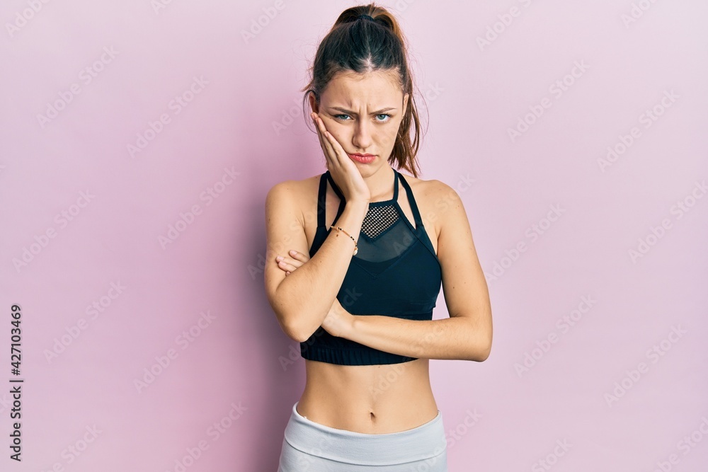 Obraz premium Young brunette woman wearing sportswear thinking looking tired and bored with depression problems with crossed arms.