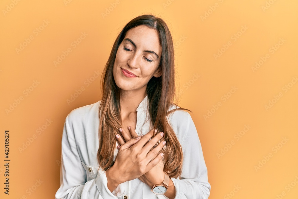 Young beautiful woman wearing casual clothes smiling with hands on chest, eyes closed with grateful gesture on face. health concept. Young beautiful woman wearing casual clothes smiling with hands on chest, eyes closed with grateful gesture on face. health concept.