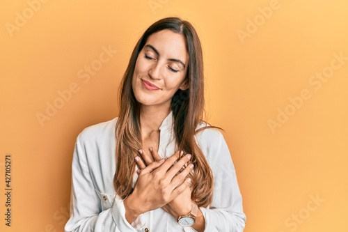 Young beautiful woman wearing casual clothes smiling with hands on chest  eyes closed with grateful gesture on face. health concept.