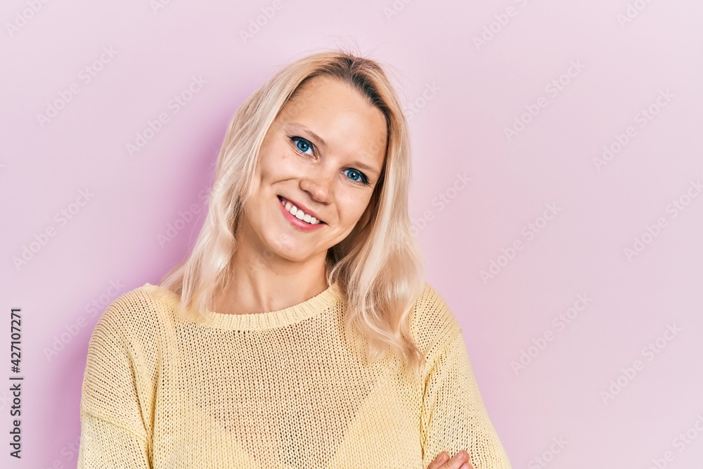 Fototapeta premium Beautiful caucasian blonde woman wearing casual winter sweater happy face smiling with crossed arms looking at the camera. positive person.