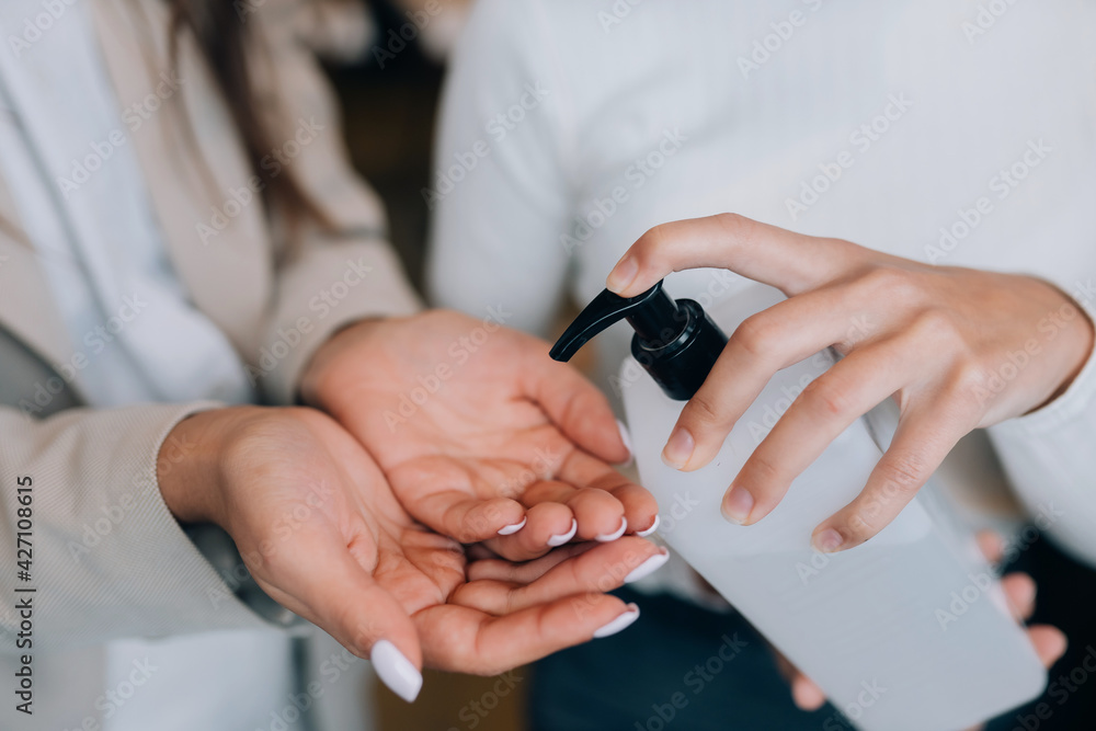 Female hands applying antibacterial liquid soap close up.