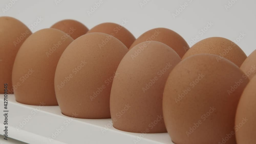 Eggs in a cardboard box, rotation shot, Chicken white fresh raw eggs in an egg container. Egg Box With Eggs On white Table Panning. Open egg box with ten brown eggs. Many fresh raw chicken eggs in car Eggs in a cardboard box, rotation shot, Chicken white fresh raw eggs in an egg container. Egg Box With Eggs On white Table Panning. Open egg box with ten brown eggs. Many fresh raw chicken eggs in car
