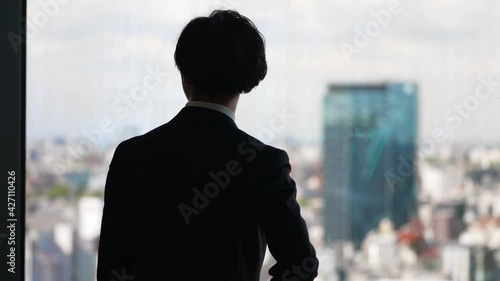 窓の外を眺めるビジネスマン