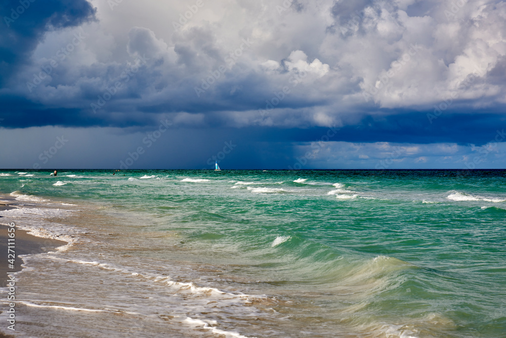 Cuba. Varadero. Beach in the morning. Sail on the background of rain clouds