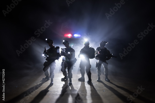 Anti-riot police give signal to be ready. Government power concept. Police in action. Smoke on a dark background with lights. Blue red flashing sirens. Dictatorship power photo