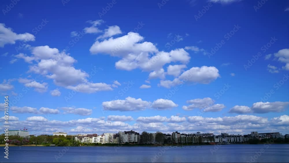 Time-lapse of waterscape in city, rolling white clouds in blue sky Time-lapse of waterscape in city, rolling white clouds in blue sky