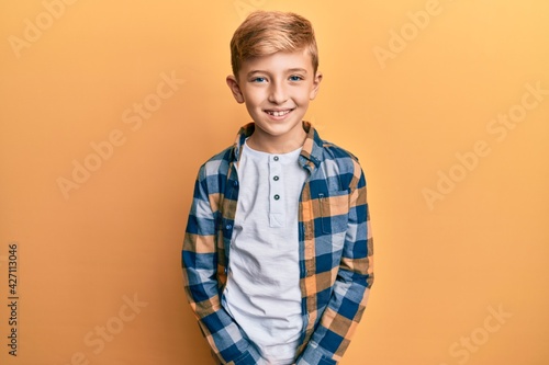 Little caucasian boy kid wearing casual clothes looking positive and happy standing and smiling with a confident smile showing teeth