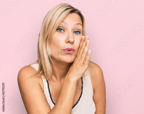 Middle age caucasian woman wearing casual clothes hand on mouth telling secret rumor, whispering malicious talk conversation