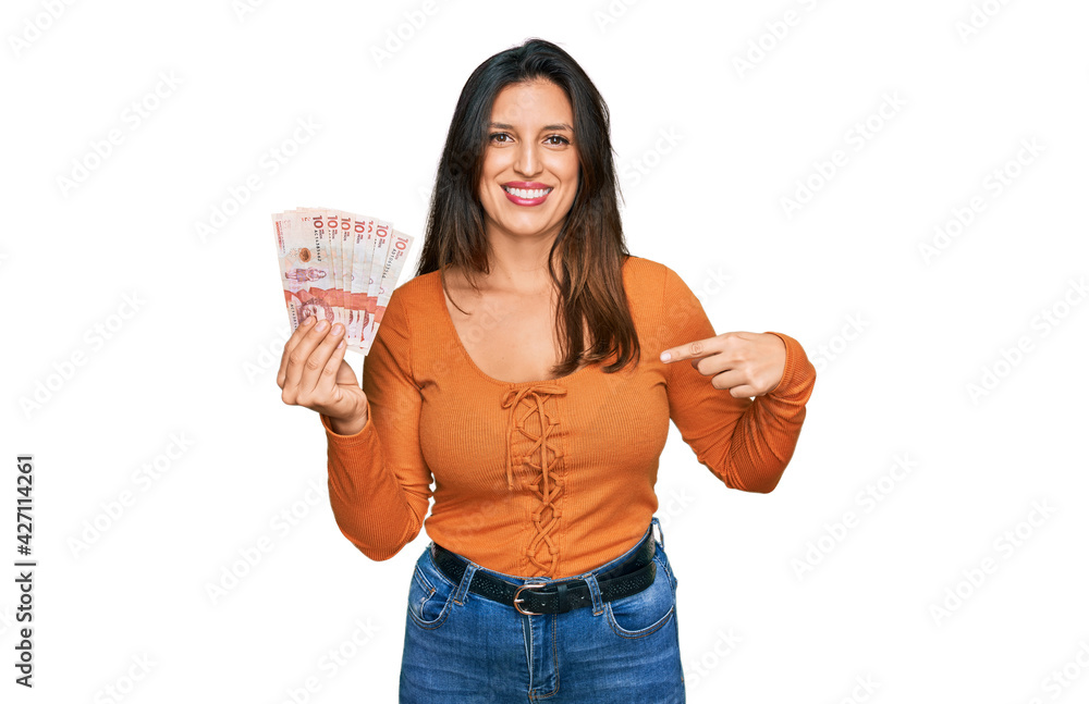 Beautiful hispanic woman holding 10 colombian pesos banknotes pointing finger to one self smiling happy and proud Beautiful hispanic woman holding 10 colombian pesos banknotes pointing finger to one self smiling happy and proud