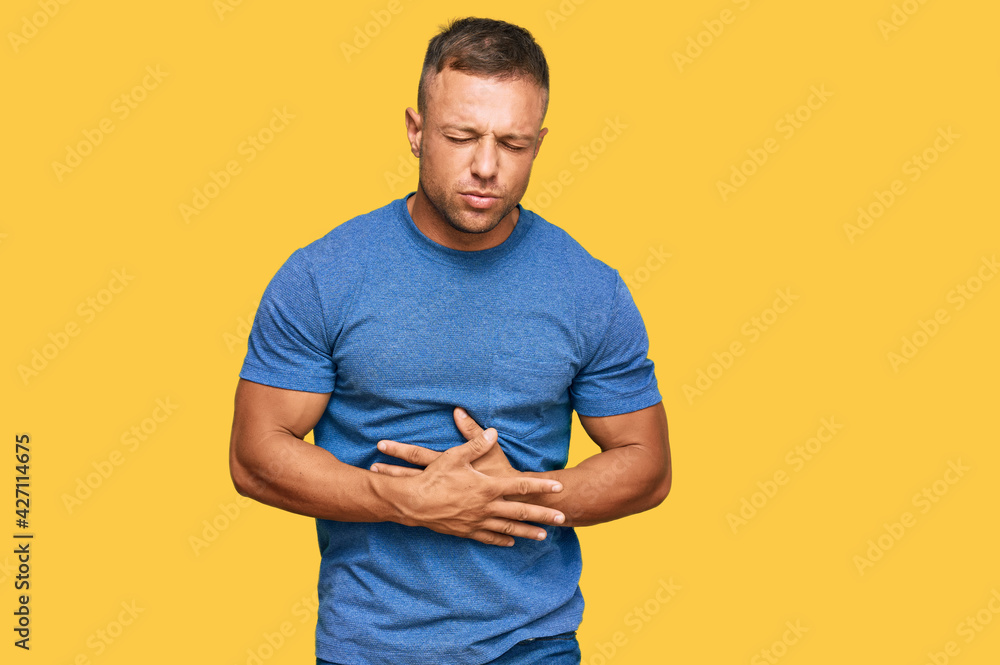 Handsome muscle man wearing casual clothes with hand on stomach because indigestion, painful illness feeling unwell. ache concept. Handsome muscle man wearing casual clothes with hand on stomach because indigestion, painful illness feeling unwell. ache concept.
