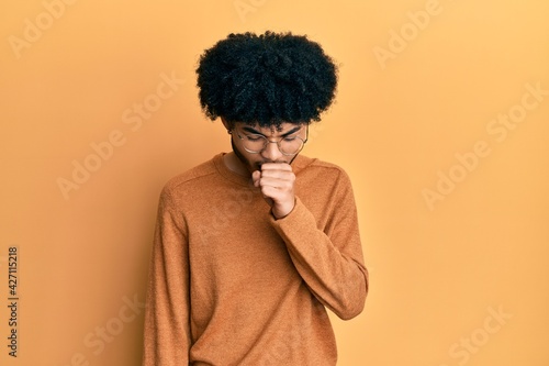 Young african american man with afro hair wearing casual winter sweater feeling unwell and coughing as symptom for cold or bronchitis. health care concept. © Krakenimages.com