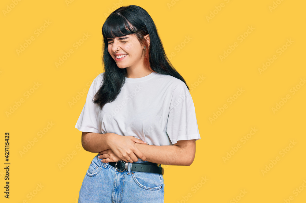 Young hispanic girl wearing casual clothes with hand on stomach because nausea, painful disease feeling unwell. ache concept. Young hispanic girl wearing casual clothes with hand on stomach because nausea, painful disease feeling unwell. ache concept.
