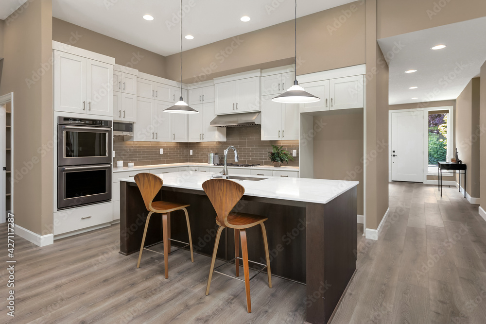 Beautiful kitchen in new luxury home with large island, pendant lights, and stainless steel appliances Beautiful kitchen in new luxury home with large island, pendant lights, and stainless steel appliances