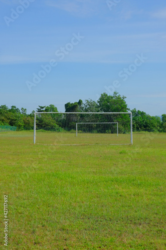 A piture of goal post and empty football field in the morning. Contact sport is not allow during Covid-19 pandemic