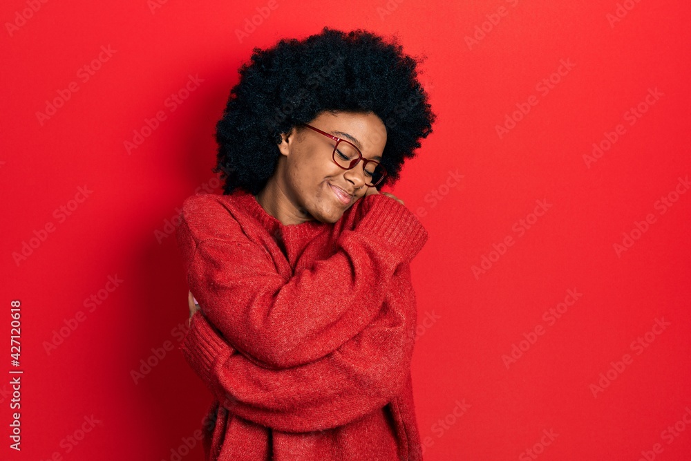 Young african american woman wearing casual clothes and glasses hugging oneself happy and positive, smiling confident. self love and self care Young african american woman wearing casual clothes and glasses hugging oneself happy and positive, smiling confident. self love and self care