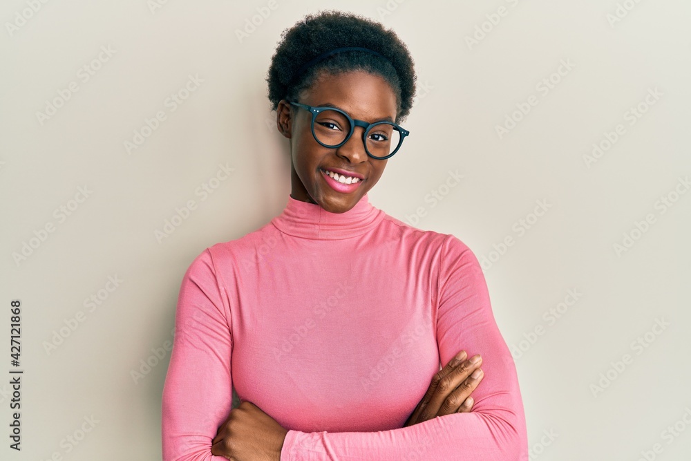 Obraz premium Young african american girl wearing casual clothes and glasses happy face smiling with crossed arms looking at the camera. positive person.