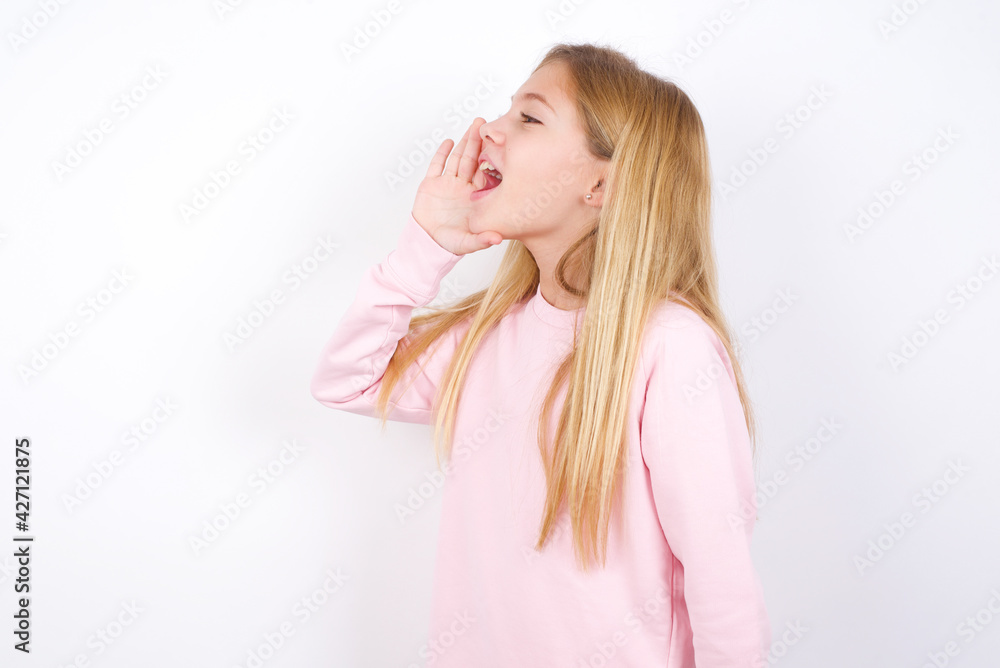 beautiful caucasian little girl wearing pink hoodie over white background profile view, looking happy and excited, shouting and calling to copy space. beautiful caucasian little girl wearing pink hoodie over white background profile view, looking happy and excited, shouting and calling to copy space.