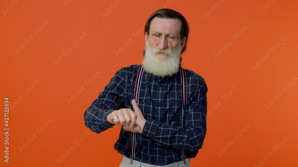 Upset elderly bearded gray-haired man showing thumbs down sign gesture, expressing discontent, disapproval, dissatisfied, dislike. Senior old grandfather on orange background. People lifestyle emotion Upset elderly bearded gray-haired man showing thumbs down sign gesture, expressing discontent, disapproval, dissatisfied, dislike. Senior old grandfather on orange background. People lifestyle emotion