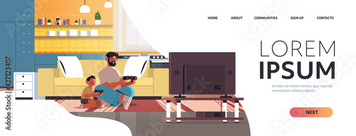 young father playing video games on game console with little son at home parenting fatherhood concept