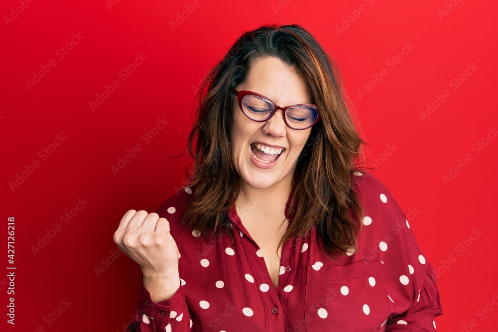 Young caucasian woman wearing casual clothes and glasses celebrating surprised and amazed for success with arms raised and eyes closed Young caucasian woman wearing casual clothes and glasses celebrating surprised and amazed for success with arms raised and eyes closed