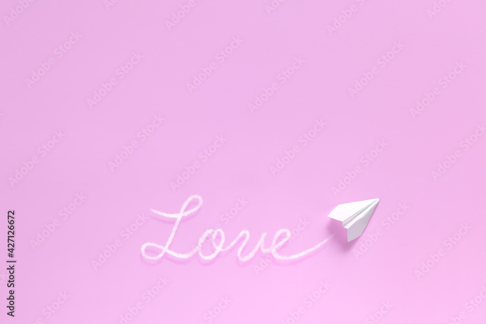 飛行機雲で文字を書く紙飛行機 1　love　ピンク背景