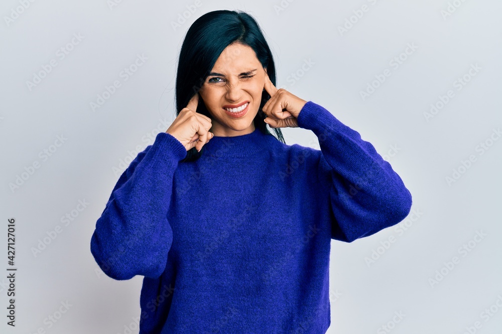 Young caucasian woman wearing casual clothes covering ears with fingers with annoyed expression for the noise of loud music. deaf concept. Young caucasian woman wearing casual clothes covering ears with fingers with annoyed expression for the noise of loud music. deaf concept.