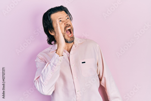 Middle age caucasian man wearing casual clothes shouting and screaming loud to side with hand on mouth. communication concept.