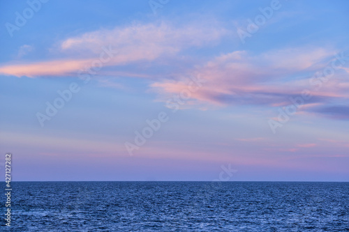 sunset and pink clouds over the blue calm sea © LeticiaLara