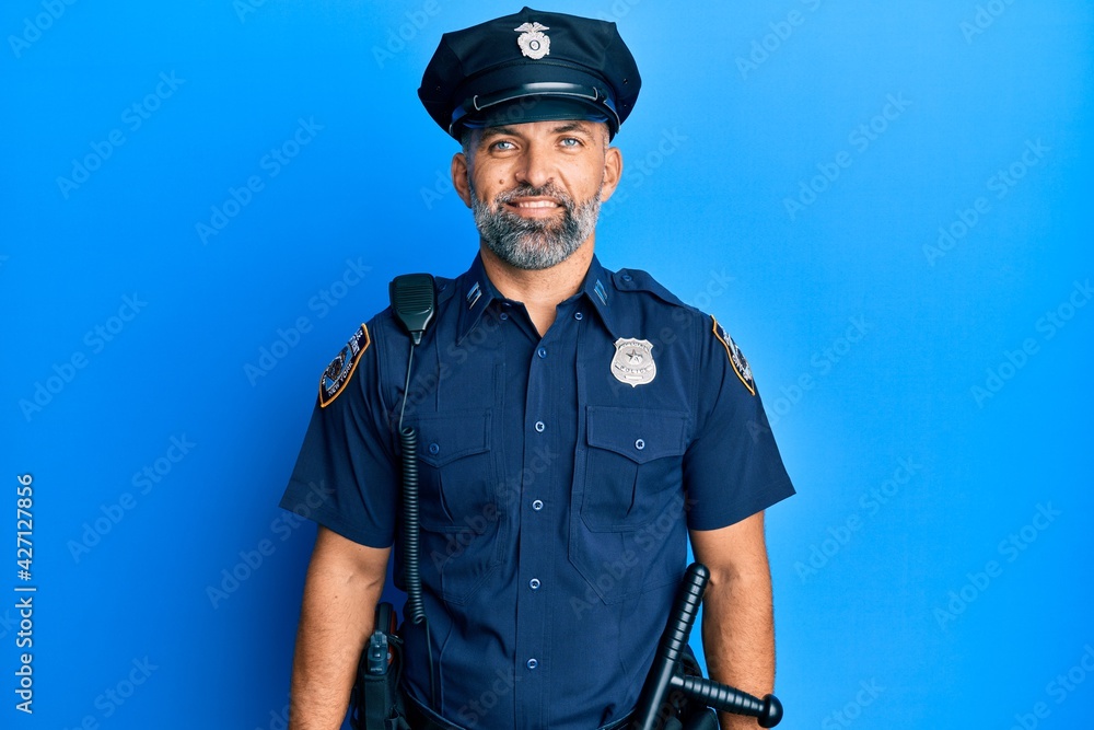 Middle age handsome man wearing police uniform with a happy and cool smile on face. lucky person. Middle age handsome man wearing police uniform with a happy and cool smile on face. lucky person.