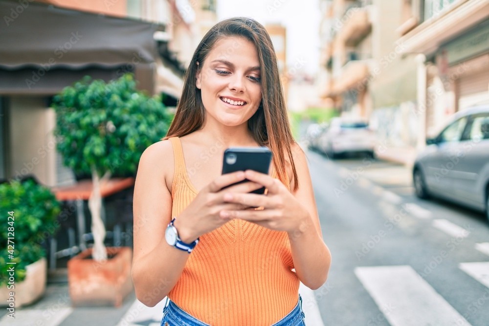 Young middle east girl smiling happy using smartphone at the city. Young middle east girl smiling happy using smartphone at the city.