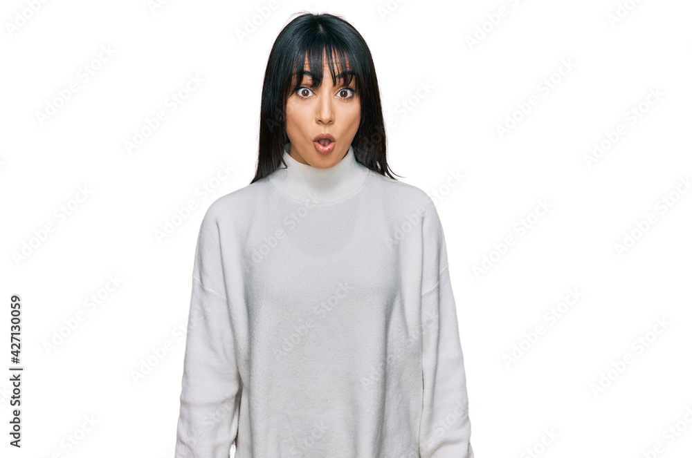 Young brunette woman with bangs wearing casual turtleneck sweater afraid and shocked with surprise expression, fear and excited face. Young brunette woman with bangs wearing casual turtleneck sweater afraid and shocked with surprise expression, fear and excited face.