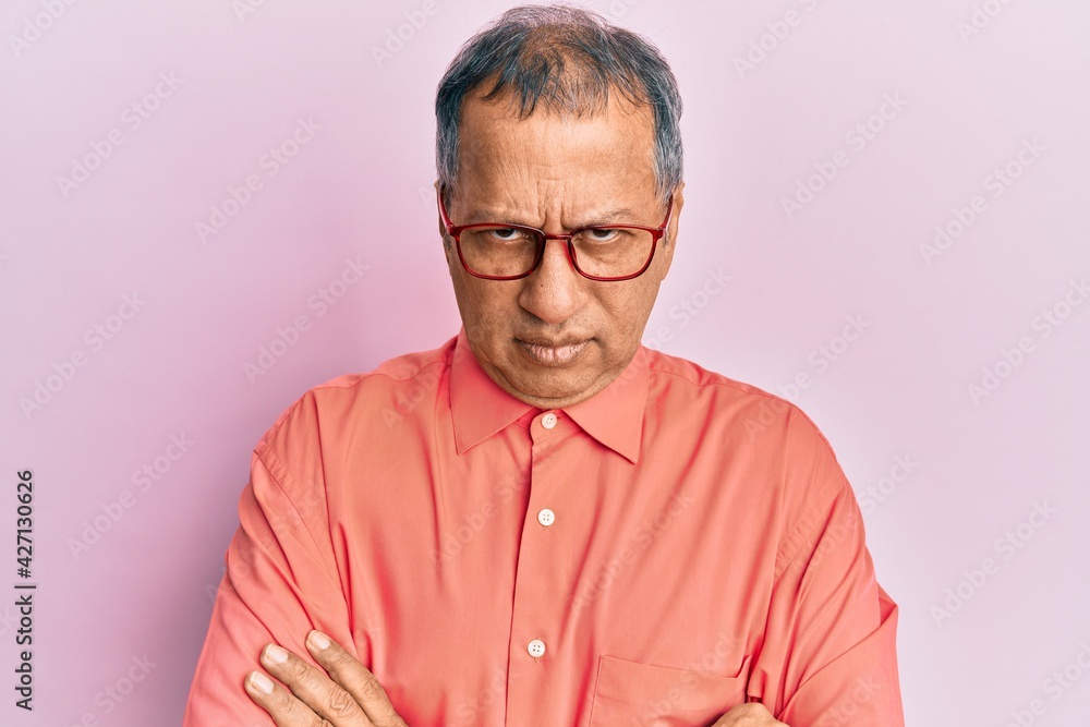 Obraz premium Middle age indian man wearing casual clothes and glasses skeptic and nervous, disapproving expression on face with crossed arms. negative person.