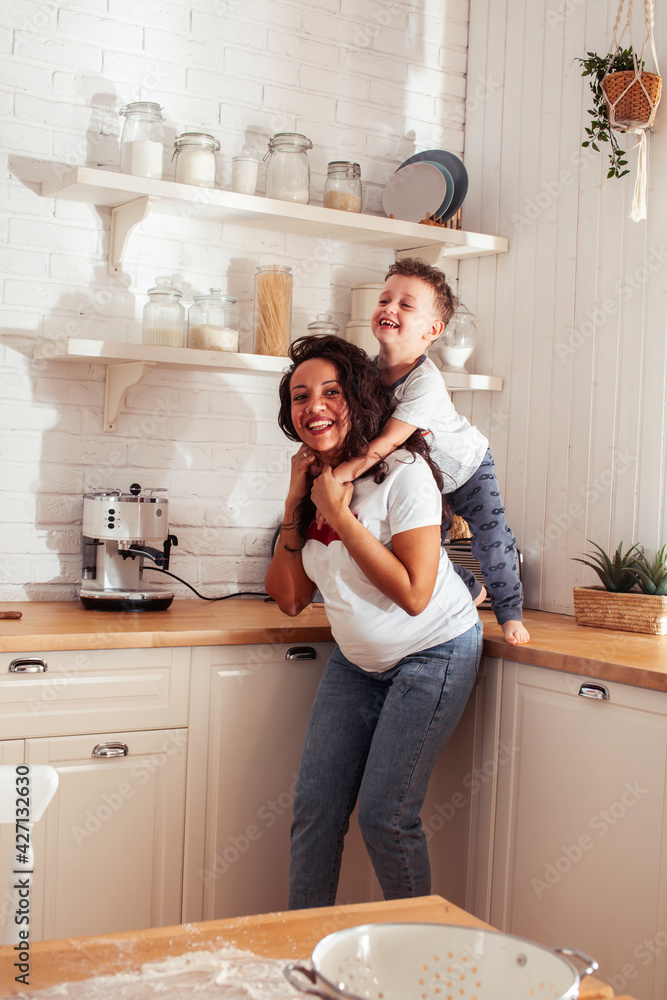 young pretty african american mother with little cute son on kitchen in morning preparing breakfast, lifestyle people concept young pretty african american mother with little cute son on kitchen in morning preparing breakfast, lifestyle people concept