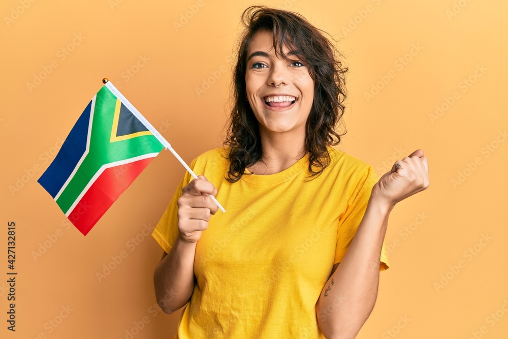 Young hispanic woman holding south african rand banknotes screaming proud, celebrating victory and success very excited with raised arm Young hispanic woman holding south african rand banknotes screaming proud, celebrating victory and success very excited with raised arm