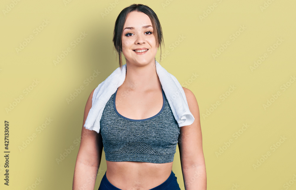 Young hispanic girl wearing sportswear and towel with a happy and cool smile on face. lucky person. Young hispanic girl wearing sportswear and towel with a happy and cool smile on face. lucky person.