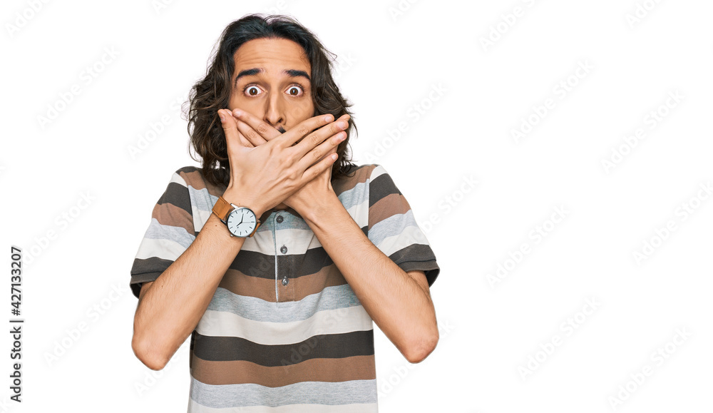 Young hispanic man wearing casual clothes shocked covering mouth with hands for mistake. secret concept. Young hispanic man wearing casual clothes shocked covering mouth with hands for mistake. secret concept.