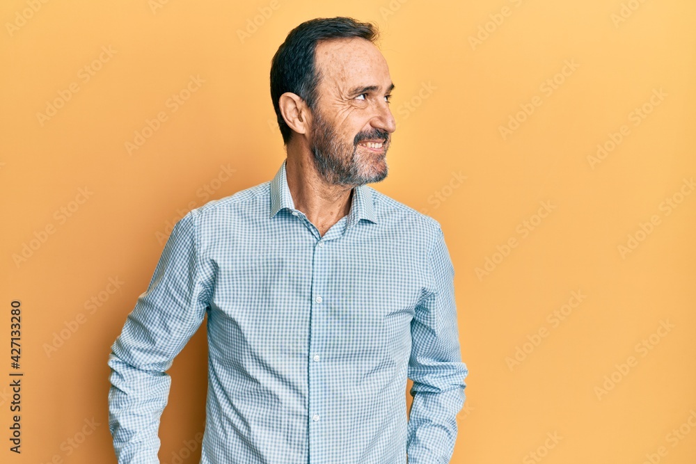 Middle age hispanic man wearing casual clothes looking to side, relax profile pose with natural face and confident smile. Middle age hispanic man wearing casual clothes looking to side, relax profile pose with natural face and confident smile.