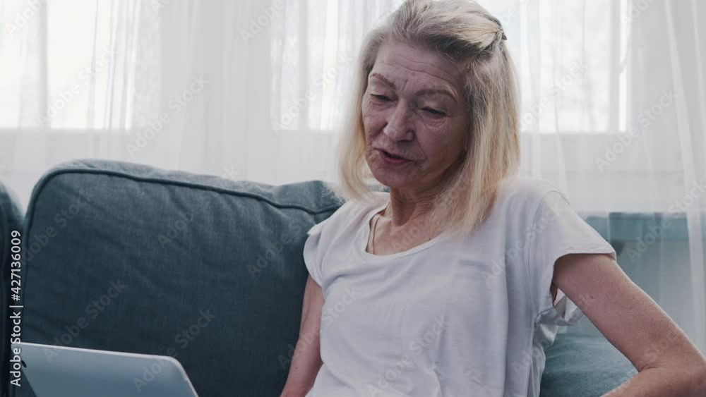 Old woman using laptop at home. Video call . High quality 4k footage Old woman using laptop at home. Video call . High quality 4k footage