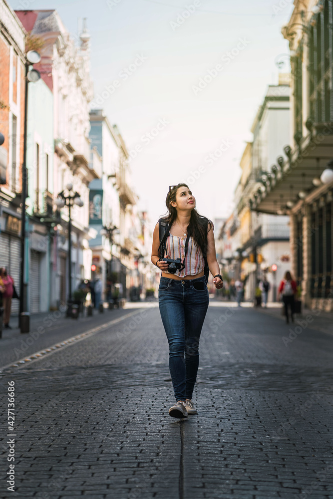 young woman walking in the middle of the street at sunset young woman walking in the middle of the street at sunset