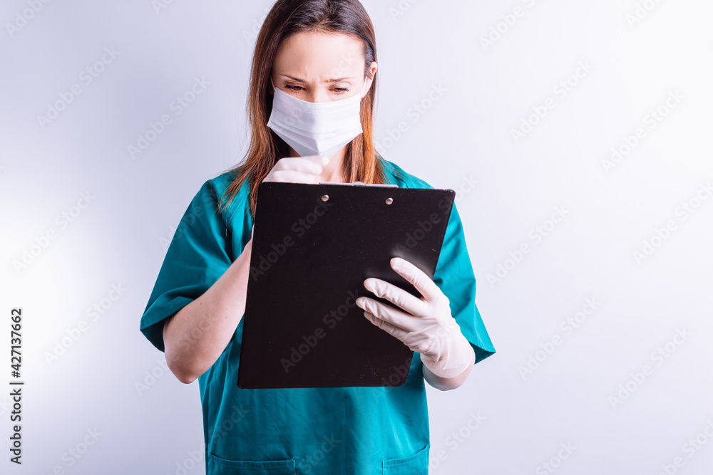 Fototapeta premium Hospital doctor with mask gloves on white background reading a full report medicine