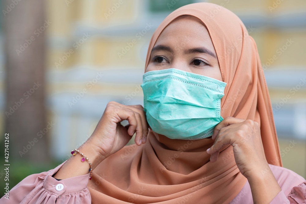 Pretty Muslim girl wearing hijab and protective mask when she goes to public, preventing the spread of the coronavirus pandemic or COVID-19 Pretty Muslim girl wearing hijab and protective mask when she goes to public, preventing the spread of the coronavirus pandemic or COVID-19