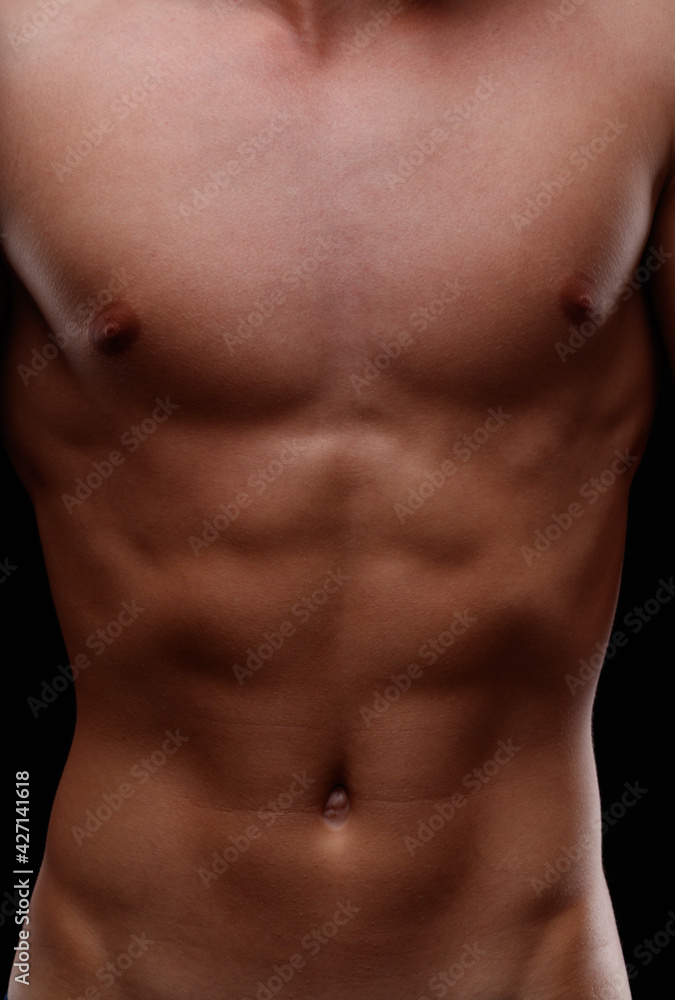 Close up on the naked flat toned torso of a young man