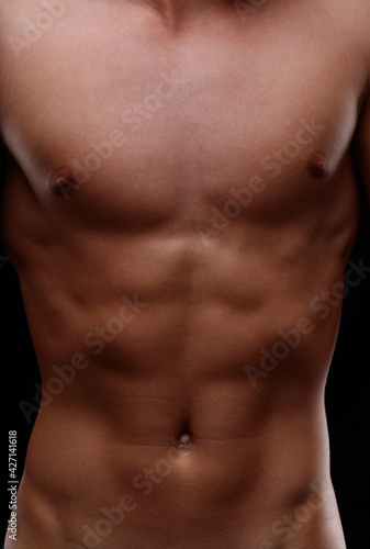 Close up on the naked flat toned torso of a young man