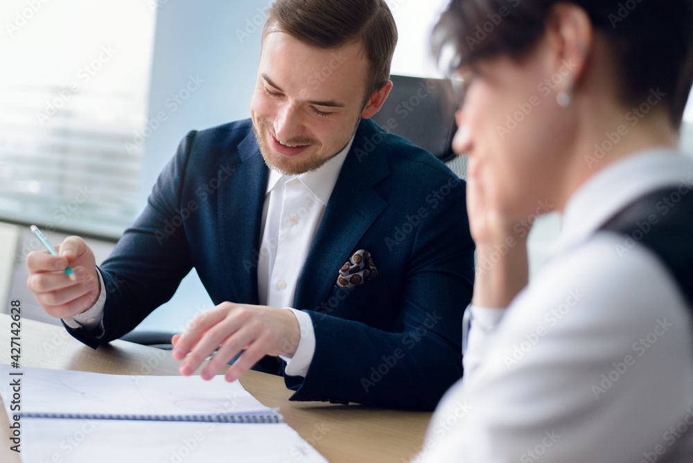 Business people working together sitting at the table against a background of the office. Business people working together sitting at the table against a background of the office.