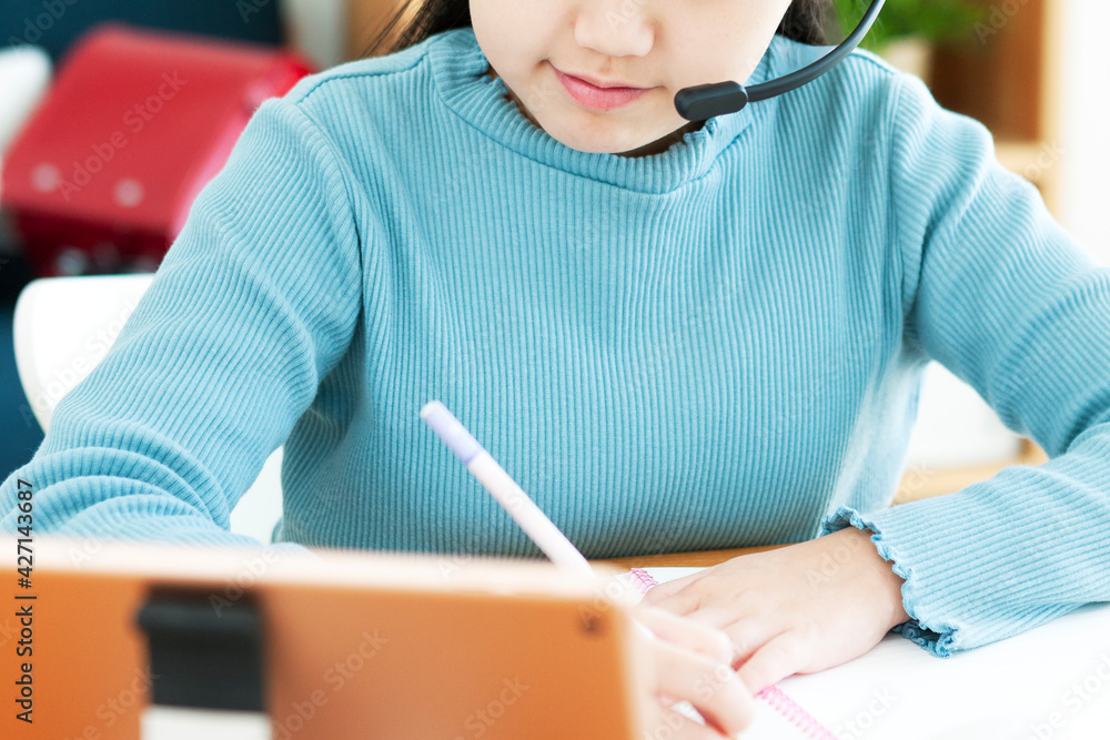 インカムをつけてタブレット端末で勉強する女の子 インカムをつけてタブレット端末で勉強する女の子