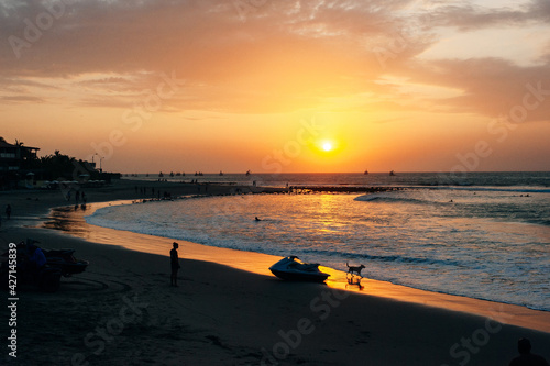 Mancora, Peru - April 2019 on the beach during sunset with the sun shine reflecting in the sea photo