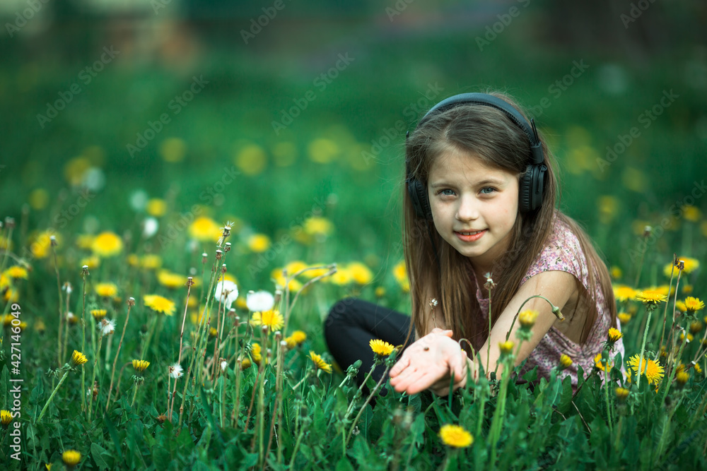 Little girl in headphones in the green field. Little girl in headphones in the green field.